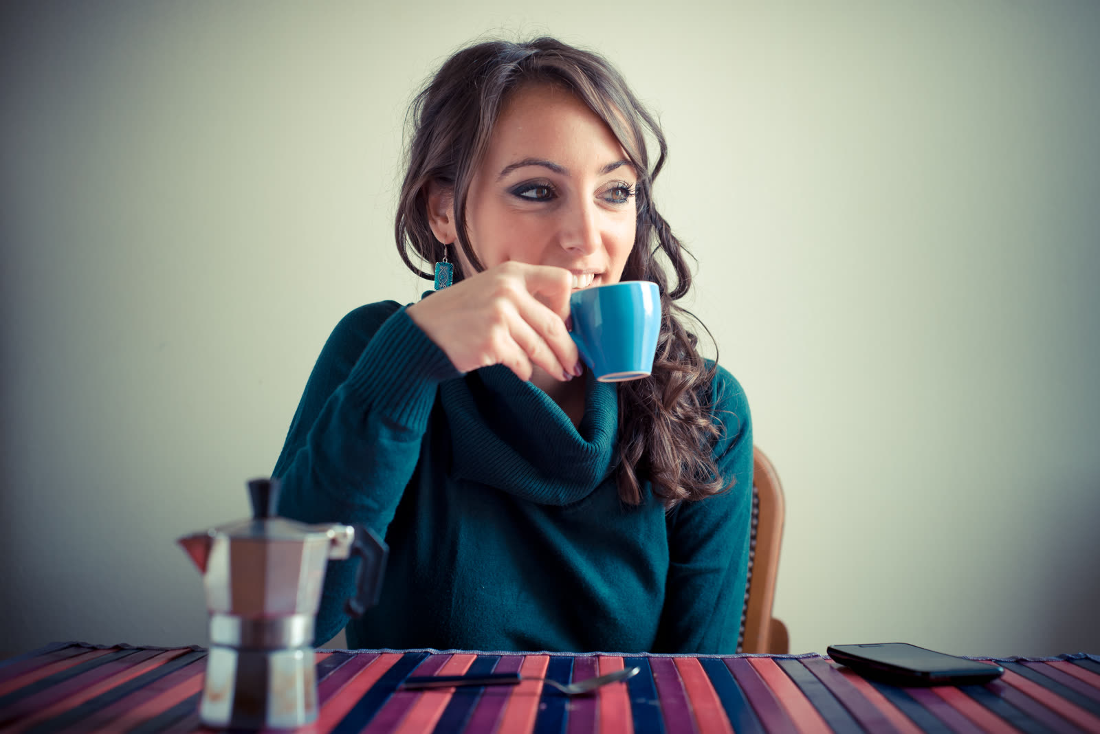 A woman having breakfast alone in morning light