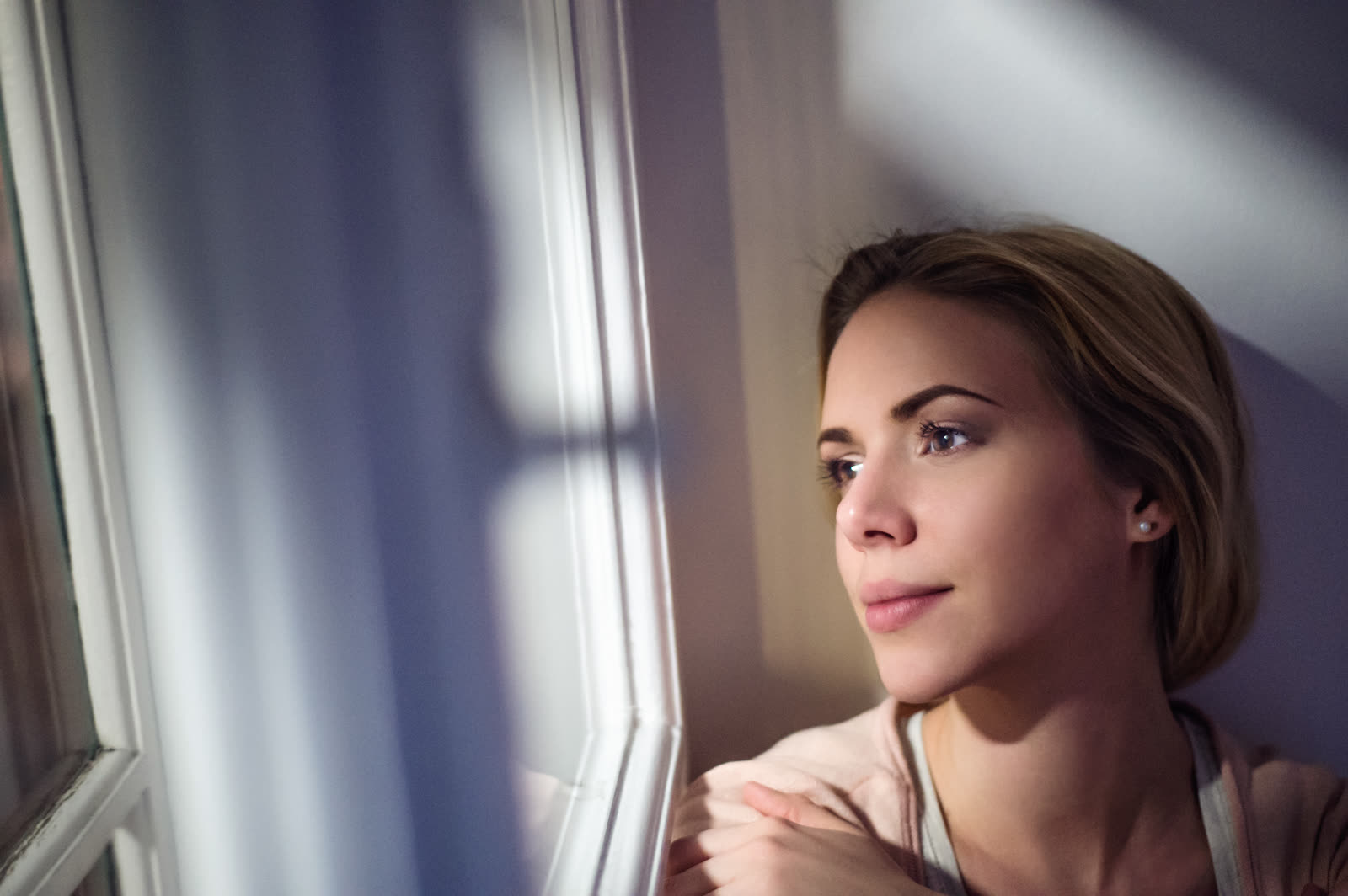 A woman sitting at a window at night