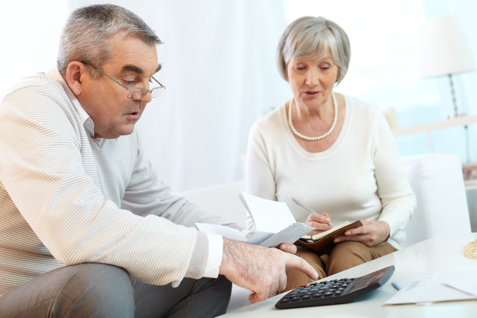 An older couple looking at household expenses
